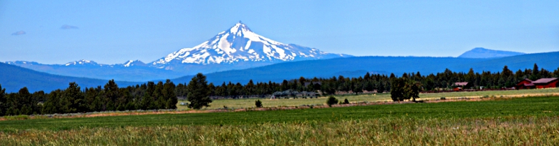 [Several photos stitched together showing more of the foreground and the land on either side of the mountain than the photo above it.]